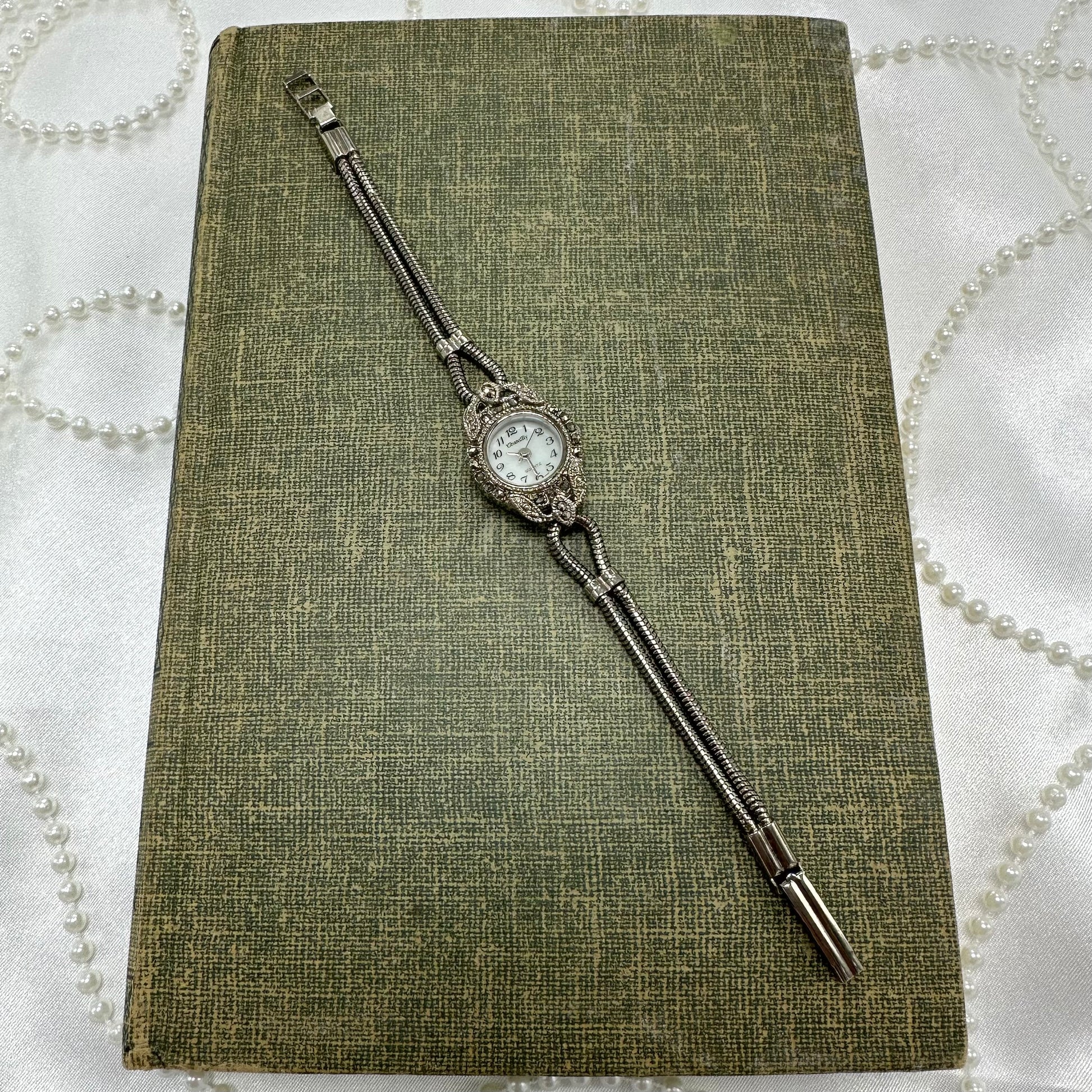 Vintage silver tone marcasite art deco style watch with unique metal band and quartz movement.