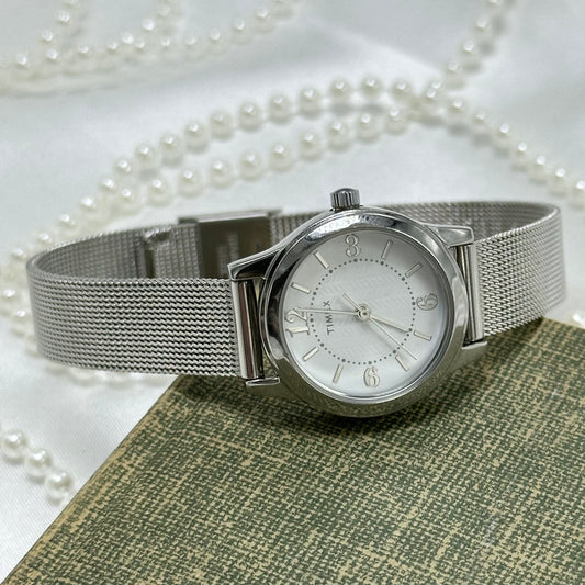 Vintage silver tone round dial Timex with quartz movement and metal mesh band.