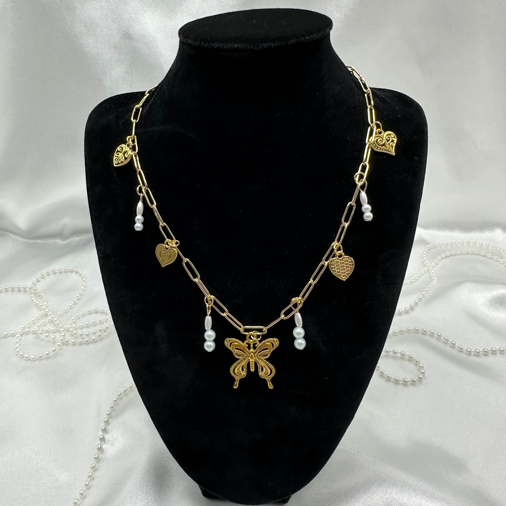 Vintage style gold tone paperclip chain necklace with heart charms and faux colored pearls.