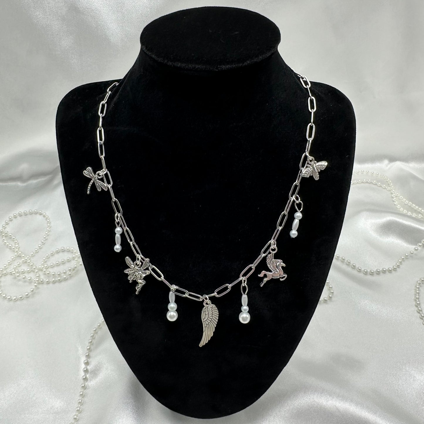 Vintage style silver tone paperclip chain necklace with wing charms and faux colored pearls.