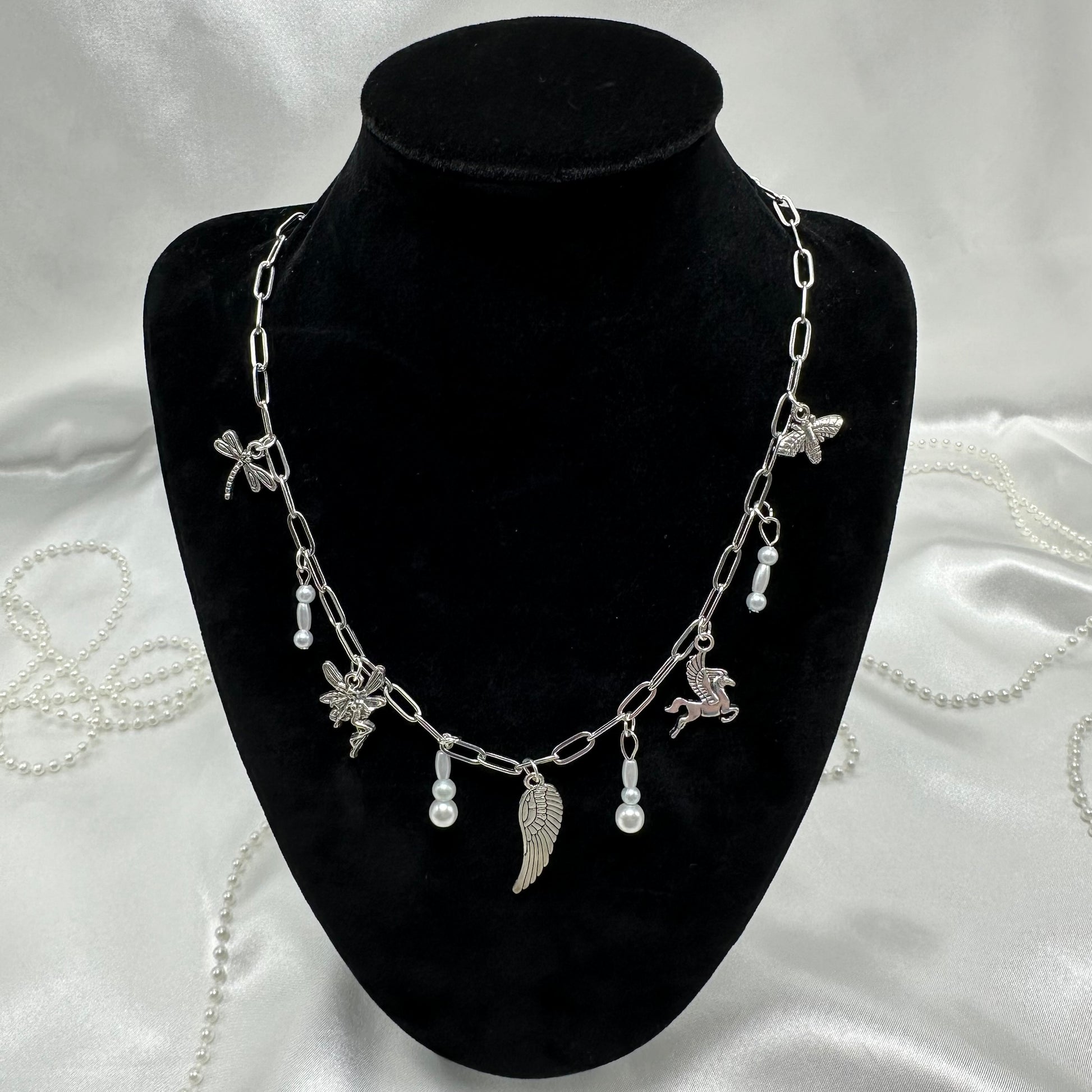 Vintage style silver tone paperclip chain necklace with wing charms and faux colored pearls.