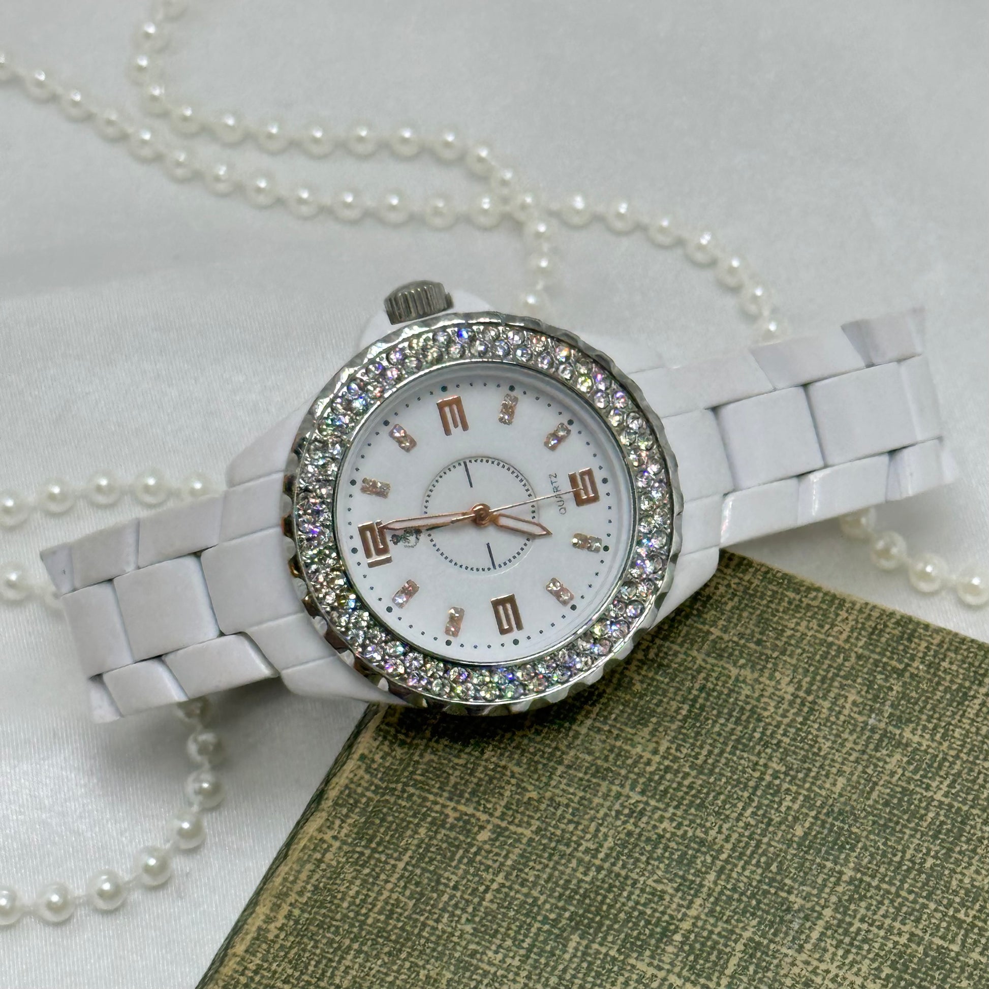 White and silver tone watch with rose gold roman numeral markers and diamanté round dial.