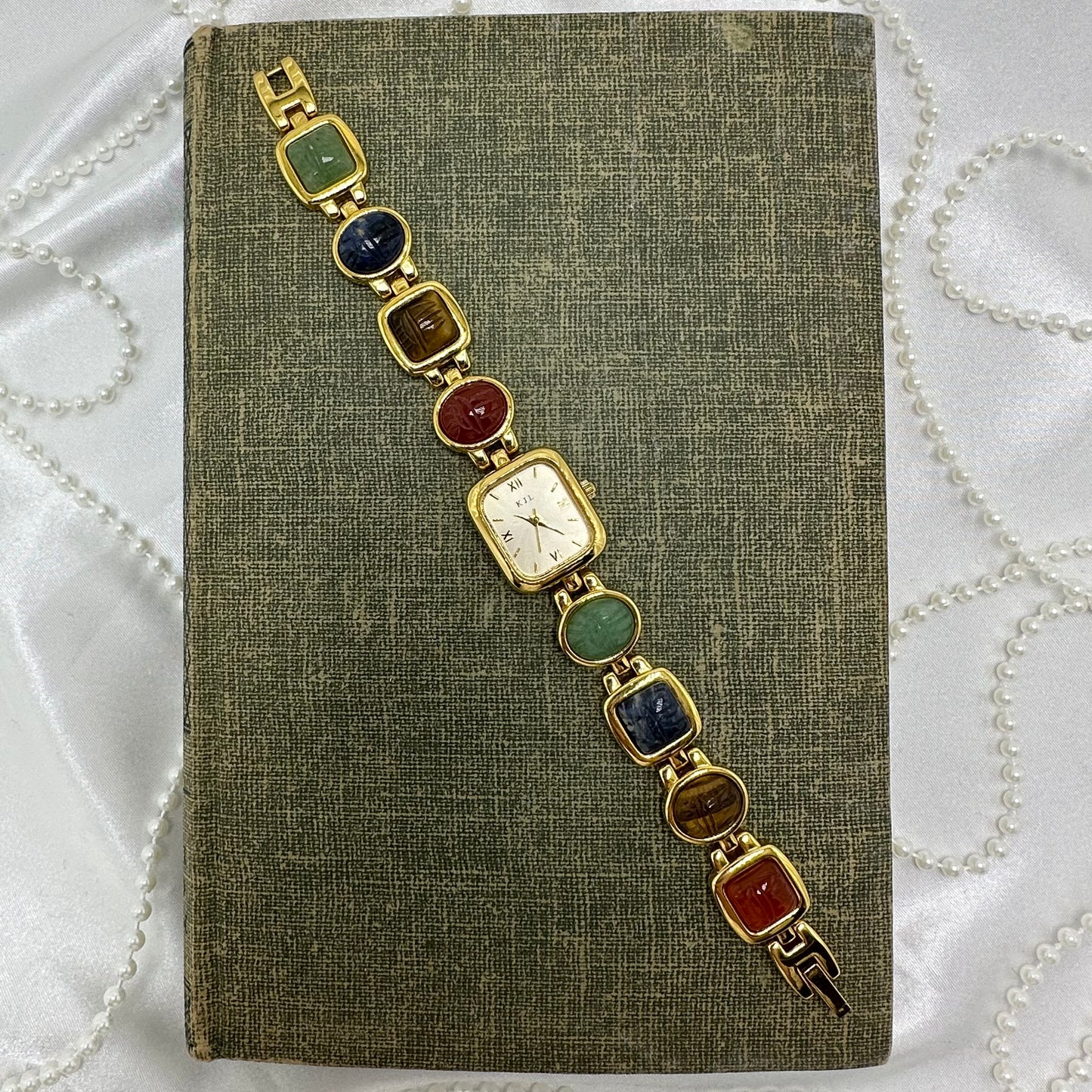 Vintage gold tone Kenneth Jay Lane watch with multicolor scarab band and quartz movement.